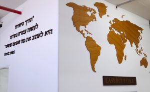 אותיות בולטות לצד מפת כדור הארץ . הכ מעץ בציפוי פורניר