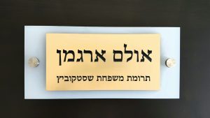 לוחית הקדשה בגוון זהב על רקע בהיר עם מחברי הרחקה